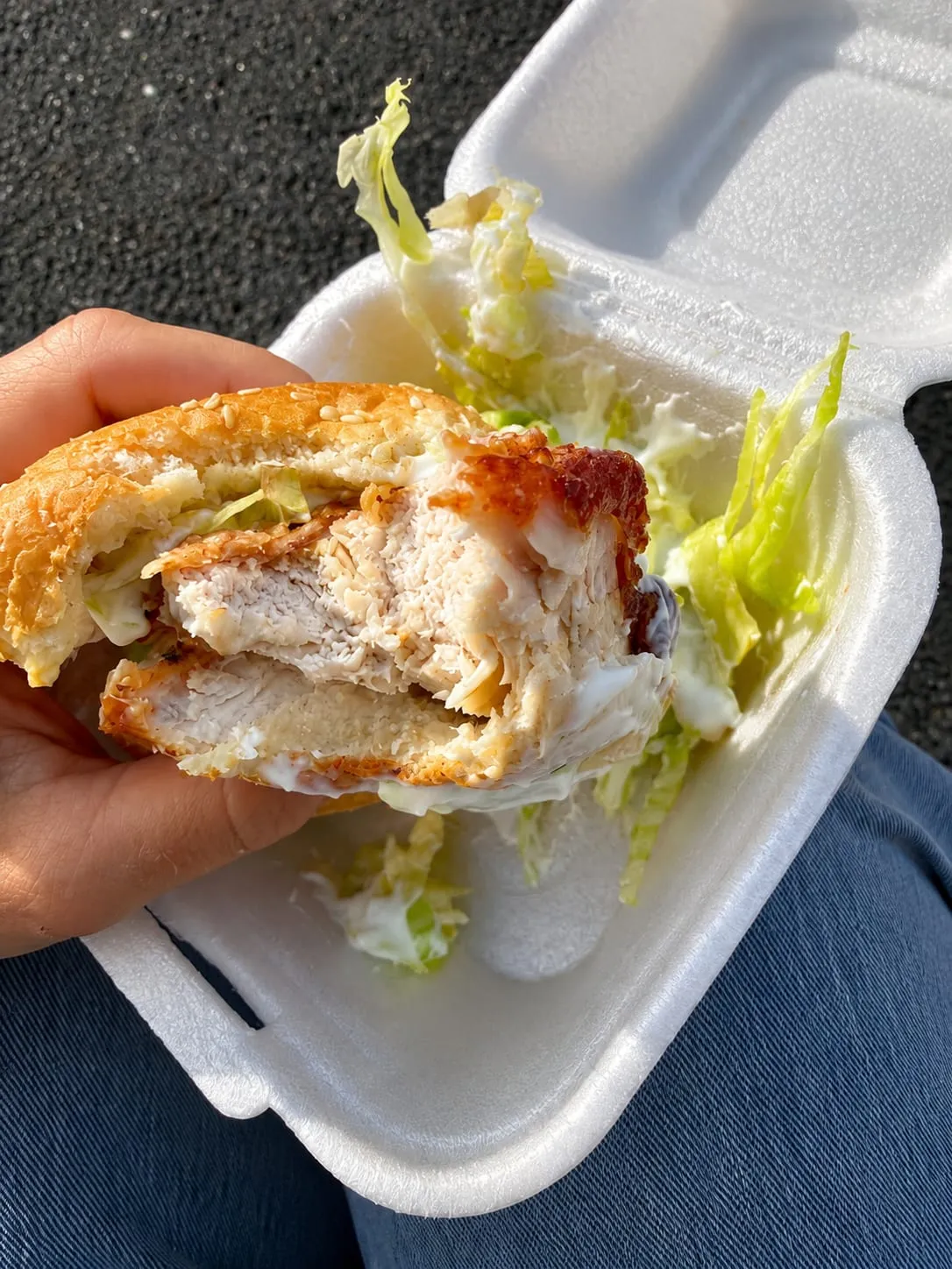 A chicken fillet burger with crisp lettuce, held in one hand