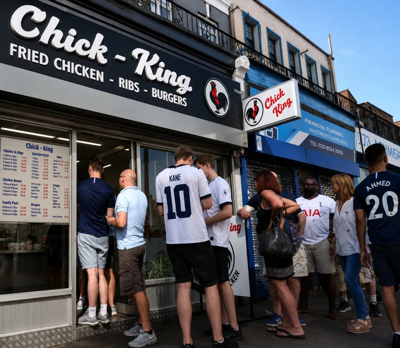 Customers in football shirts outside the shop, menu board visible in the window