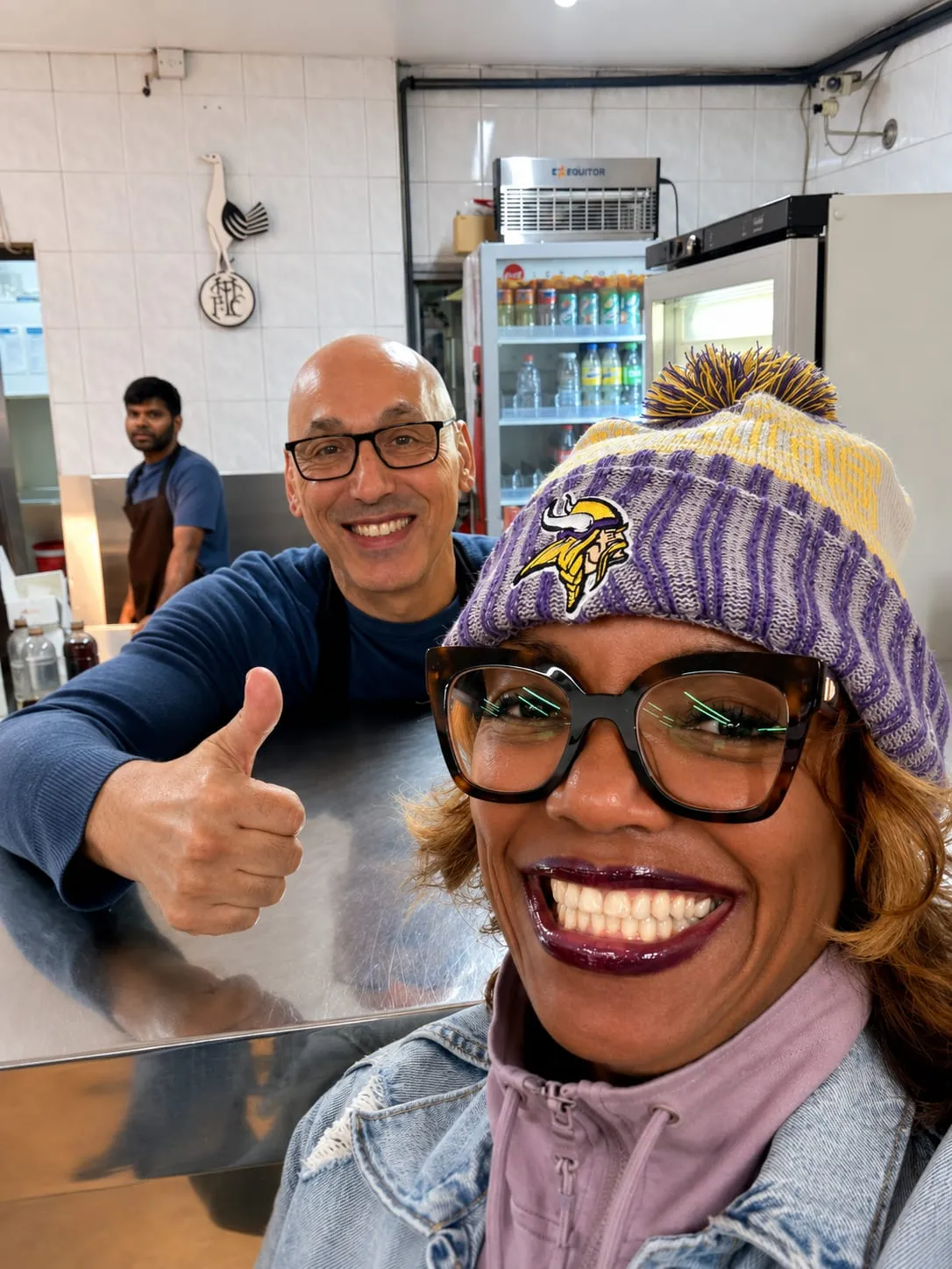 A member of the Chick King team and a smiling customer behind the counter