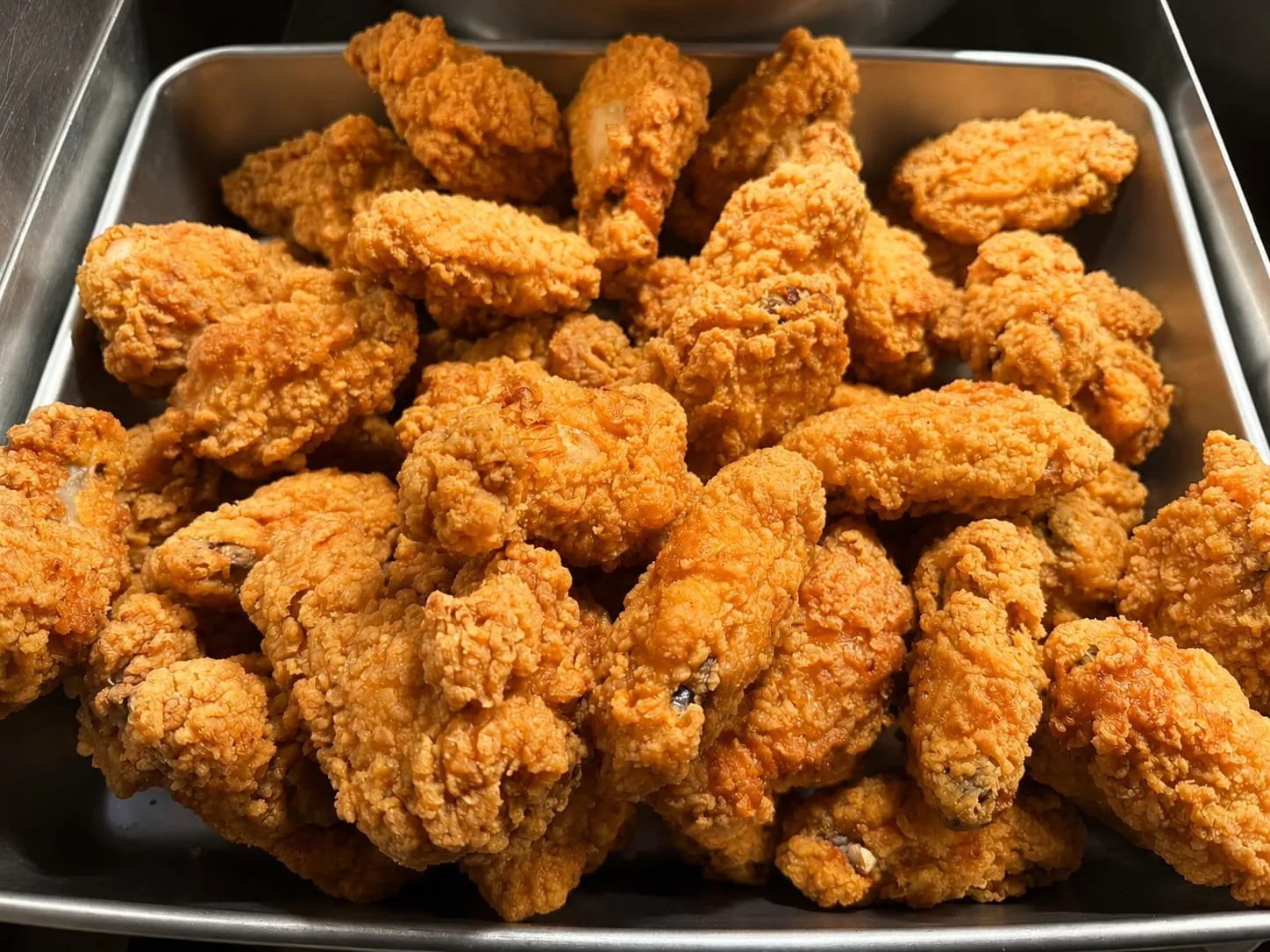 A tray of freshly fried chicken pieces ready for a family pack